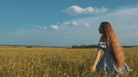 Pretty girl running through yellow wheat field. Happy beautiful young woman Stock Footage