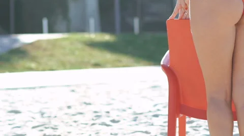 Pretty girl in santa hat stand in pose near the chair on the beach. Slowly Stock Footage