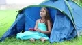 Pretty girl sits on grass near tourist tent and uses his smartphone HD Footage