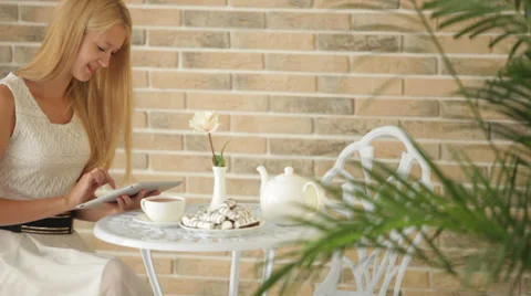 Pretty girl sitting at cafe using touchpad looking at camera and smiling Video stock 35091590