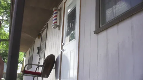 Pretty girl sitting in front of a country barber shop 動画素材 30872853