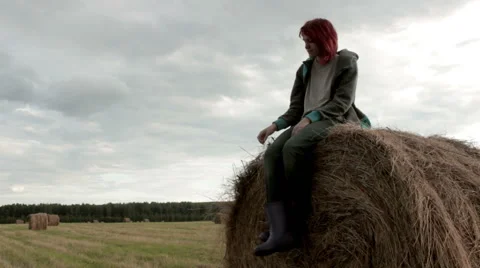 Pretty girl is sitting on haystack  Stock Footage 54349516