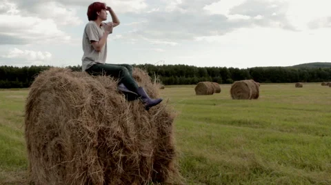 Pretty girl is sitting on haystack  Stock Footage 54350601