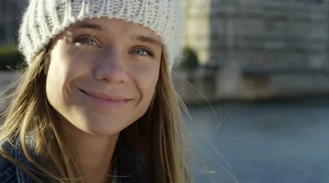 Pretty girl sitting by the river while in the city. Video stock 63027692