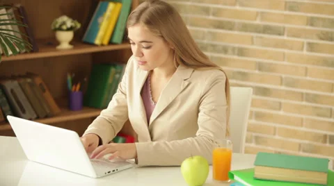 Pretty girl sitting at table using laptop holding credit card looking at camera Stock Footage 34114149