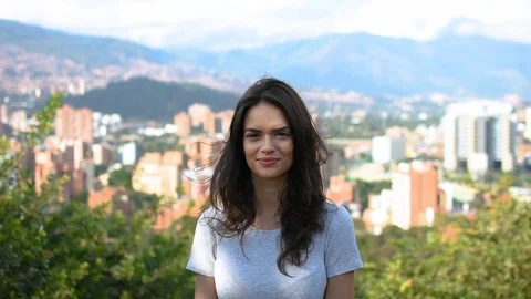 Pretty girl smiling and posing in front of city panorama Video stock 101208032
