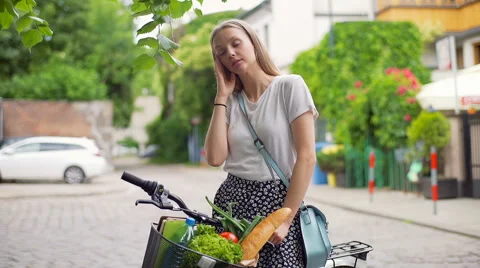 Pretty girl standing with the bike on pathway and having a headache Stock Footage