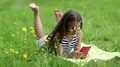 Pretty girl in sunglasses with red smartphone lies on the grass HD Footage