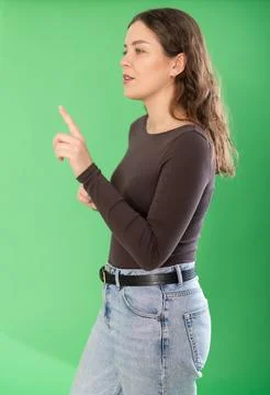 Pretty girl taps her finger on virtual screen in front of her. Chroma key Stock Photos
