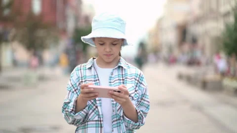 Pretty girl texting on smartphone while walking in street. Stock Footage 245733406