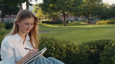 Pretty girl thinks questioningly and finding solution idea while write and make Vídeo Stock 289399862