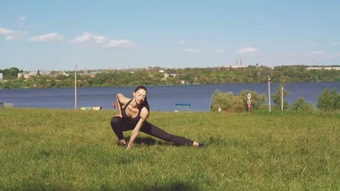Pretty girl training gymnastic exercises in the park in 4K Stock Footage