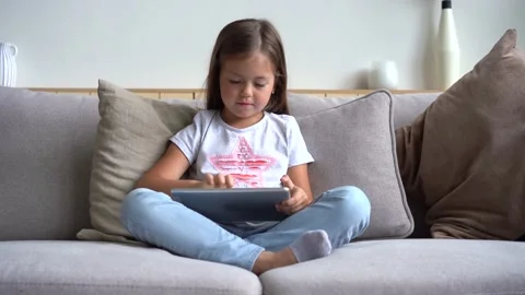 Pretty girl using digital table at home. Concept of modern device Stockbeeldmateriaal 139208589