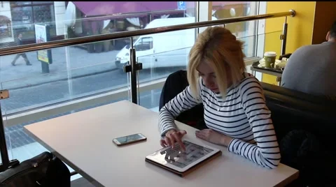 Pretty girl is using tablet PC at the cafe Stock Footage 63168583