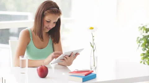 Pretty girl using touch pad drinking water and smiling at camera Stock Footage 25484540