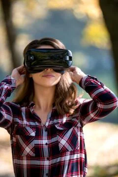 Pretty girl using VR headset outside in the park Stock Photos