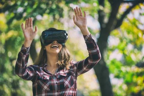 Pretty girl using VR headset outside in the park Stock Photos