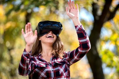 Pretty girl using VR headset outside in the park Stock Photos