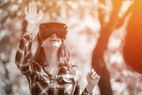 Pretty girl using VR headset outside in the park Stock Photos
