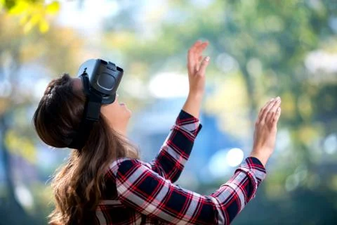 Pretty girl using VR headset outside in the park Stock Photos