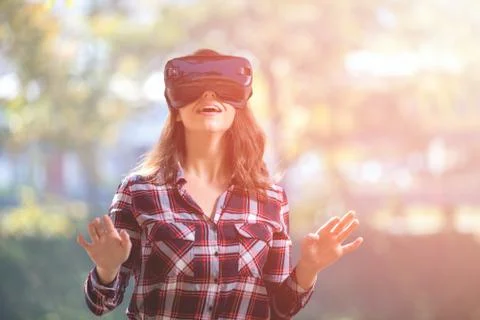 Pretty girl using VR headset outside in the park Stock Photos