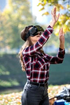 Pretty girl using VR headset outside in the park Stock Photos
