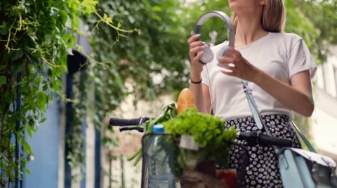 Pretty girl walking with bicycle and listening music, steadycam shot Stock Footage