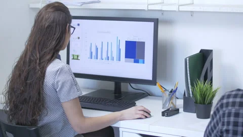 Pretty hardworking lady working in front of a computer monitor at the office Stock Footage 142225594
