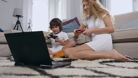 Pretty high-spirited 30-aged woman with curly hair playing video game using Stock Footage 120540215