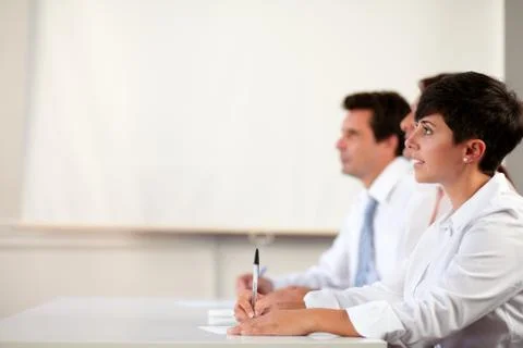 Pretty hispanic executive looking at presentation Stock Photos