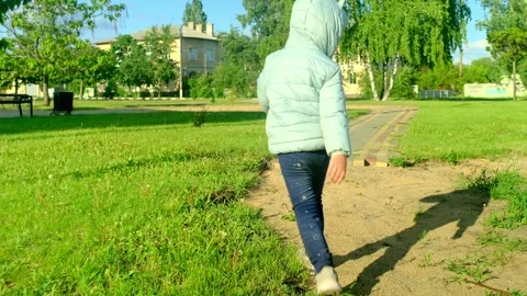 Pretty kid playing and smiling outside in a park. Happy little girl playing outs Stock Footage 277439243