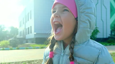Pretty kid playing and smiling outside in a park. Happy little girl playing ou Stock Footage 277549271