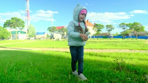 Pretty kid playing and smiling outside in a park. Happy little girl playing outs Stock Footage 277624804