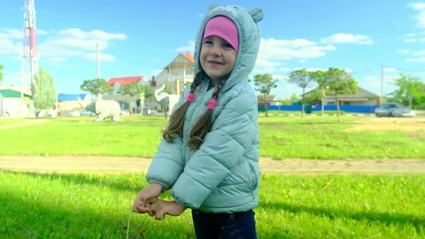 Pretty kid playing and smiling outside in a park. Happy little girl playing outs Stock Footage 278054053