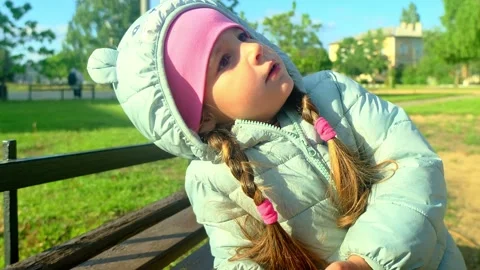 Pretty kid playing and smiling outside in a park. Happy little girl playing outs Stock Footage 278345209