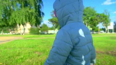 Pretty kid playing and smiling outside in a park. Happy little girl playing outs Stock Footage 279874337