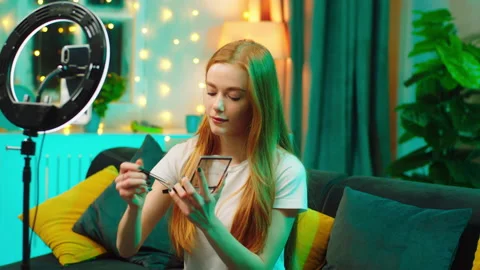 Pretty lady doing a makeup in front of the phone using a ring light to make a Stock Footage 146465651
