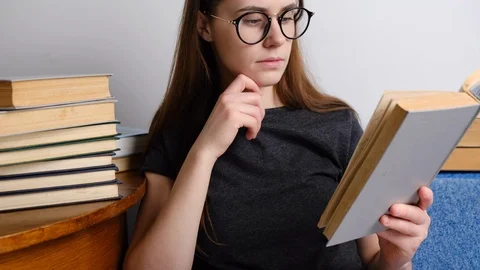 Pretty lady in eyeglasses reading old book Stock Footage 125332940