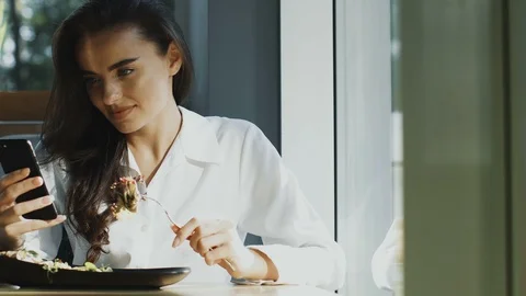Pretty lady in formal clothes having food in restaurant and using phone Stock Footage 117146208
