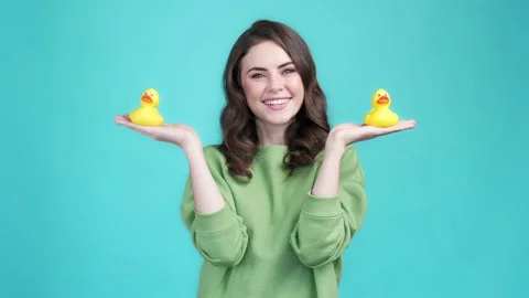 Pretty lady hold hands plastic birds ducks isolated cyan color background Video stock 169943501