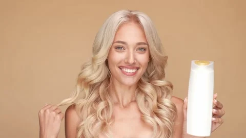 Pretty lady hold shampoo touch wavy hairdo isolated pastel color background Stock Footage 166104015