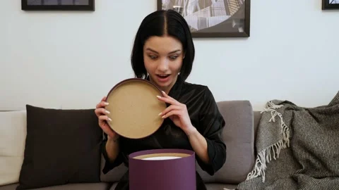 Pretty lady opening a big box. Brunnete woman is surprised and happy with her Stock Footage 149066730