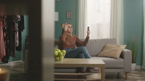 Pretty lady talks on video call and bites red apple Stock Footage 150281889
