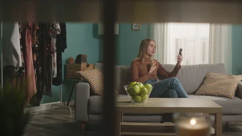 Pretty lady talks on video call and bites red apple Stock Footage 150283119