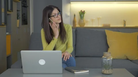 A Pretty Lady Working From Home And Picking Up Her Phone Video stock 128366167