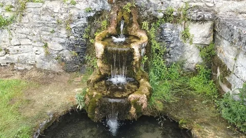 Pretty little garden waterfall with its flowing water Stock Footage 109847853