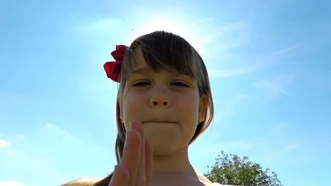 A pretty little girl give kiss to camera in sunny day. Stock Footage