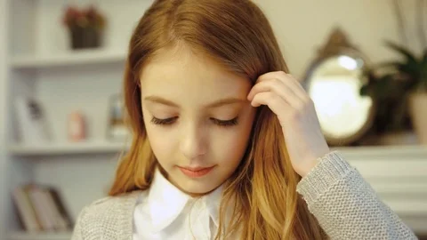 Pretty little girl opening eyes, looking at camera and smiling in the living Stock Footage