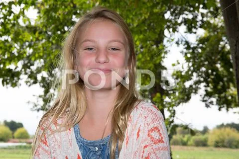 Pretty little girl smiling in a park close-up Stock Photos
