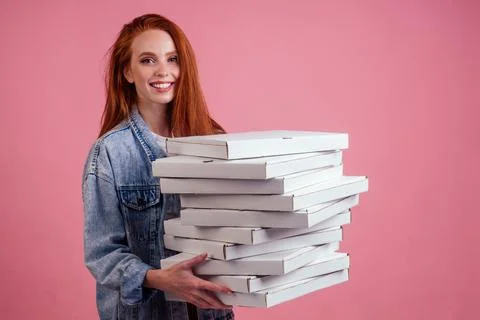 Pretty long ginger red-haired woman holding a lot of boxes with fast food snack Stock Photos